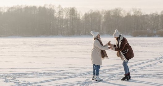 Couples ice skating in the snow during winter time