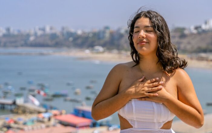 women meditating by the beach